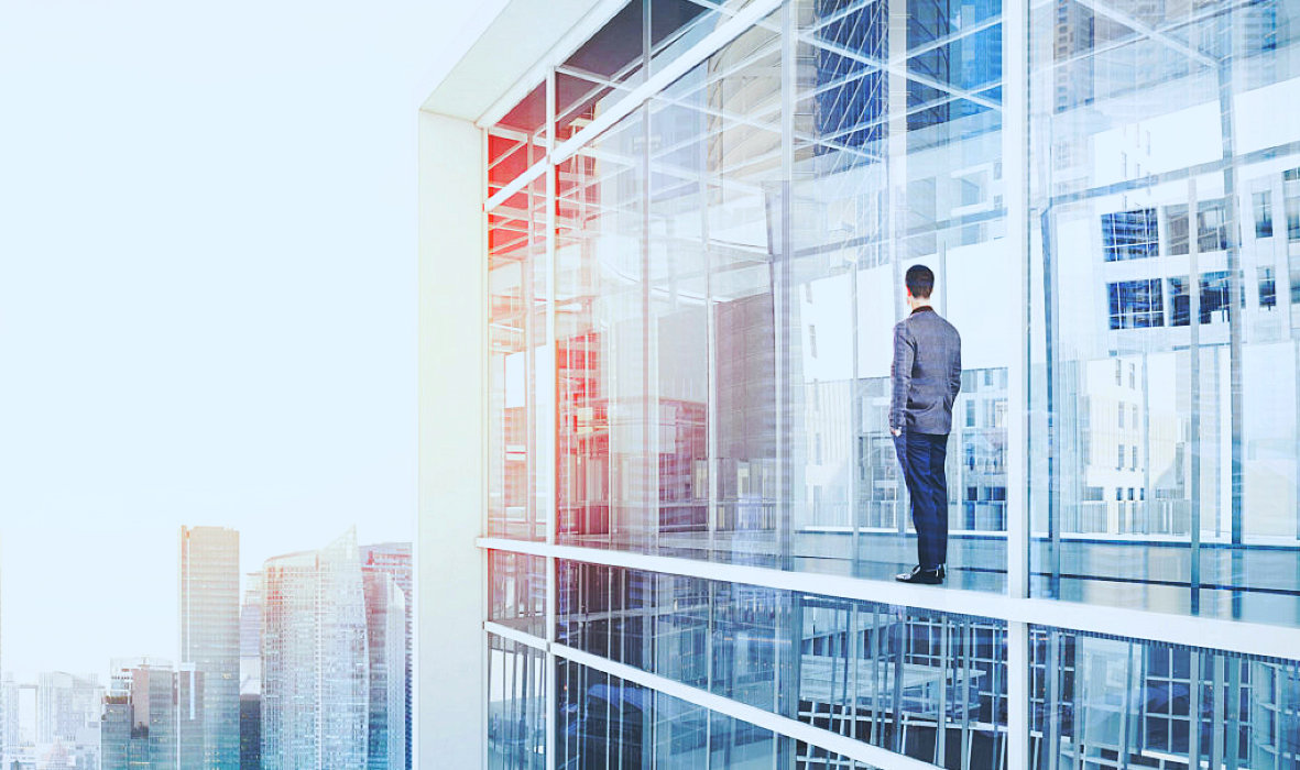 man standing looking over the glass window of a building